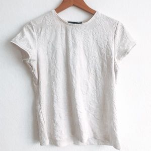 White short sleeve shirt with floral detailing.